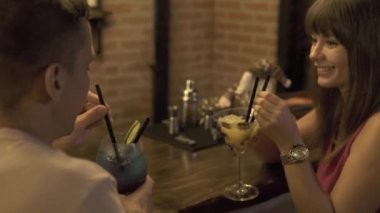 İki adam ve kadın alkollü kokteyl oturan bar counter romantik tarih süre restoranda içme sonra. Genç çift kafede parti kokteyl içme.
