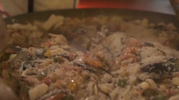 İspanya paella tavası taze deniz ürünleri ile hazırlanıyor. Lokanta mutfağı pişirme sırasında İspanyol paella karıştırma pişirin. Pişirme gıda kavramı. Sağlıklı beslenme. Geleneksel İspanyol mutfağı. — Stok video