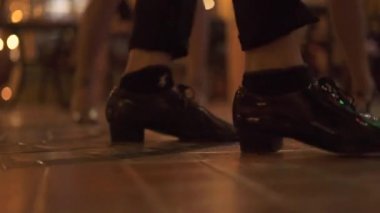 Erkek dans pistinde dans ayakkabılarına bacaklarda kapatın. Erkek dansçı gece kulübünde. İnsanlar having oyunculuk müzik diskotek.