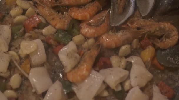 홍합, 새우, 오징어를 뜨거운 냄비에 요리와 해산물 빠에야. 스페인 음식 빠에야 팬에 해산물 요리를 닫습니다. 스페인 요리 개념입니다. 음식 배경. — 비디오
