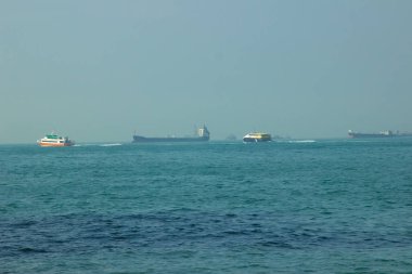 Kargo gemisi ve mavi deniz manzarası arka plan üzerinde yüzen tekne. Mavna üzerinde ufuk manzara mavi okyanus gemisiyle.