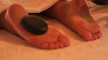 Taş ayak masajı spa salonda. Ve tedavi sırasında ayak masaj için sıcak taş spa de koyarak Massagiste. Güzellik ve vücut bakım kavramı. Zen ve gevşeme.