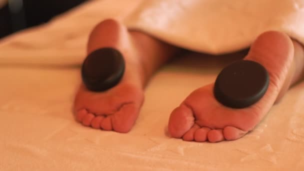 在豪华水疗沙龙享受石质按摩和治疗 关闭脚的年轻女子得到石头按摩在水疗沙龙 身体放松和护肤的概念 禅宗理念 — 图库视频影像