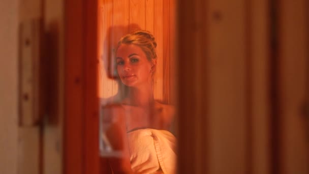 Schöne Frau in Badetuch gehüllt Sauna im Beauty-Wellness-Salon. erholsame Frau genießt Badehaus im Kurort. Körper- und Hauttherapie. Schönheitsbehandlung. Gesunder Lebensstil. — Stockvideo