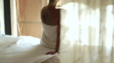 Genç kadın banyo havlusu yatak yatak odası açık pencerede oturup sarılı. Banyo, güzel kadın bekleyen sevgilisi. Cinsel sorunlar ve ilişkiler çift aşık.