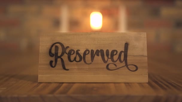 Sinal de mesa reservada para assento de reserva no restaurante à noite para jantar à vela. Mesa reservada etiqueta de madeira em restaurante de luxo ou café para data romântica e jantar com velas . — Vídeo de Stock