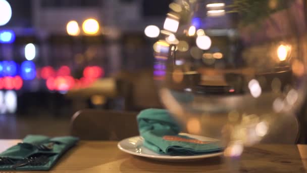 Verre à vin pour dîner debout sur la table dans un élégant restaurant tout près. Serveuse servant une table pour un couple romantique dans un café branché. Vin glas pour rendez-vous romantique au restaurant . — Video