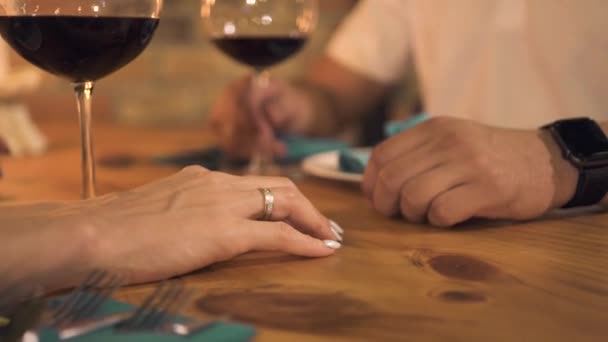 Tangan laki-laki menyentuh tangan perempuan saat kencan romantis di restoran malam. Wanita menyentuh tangan pacar di atas meja di makan malam di kafe elegan. Hubungan romantis orang . — Stok Video