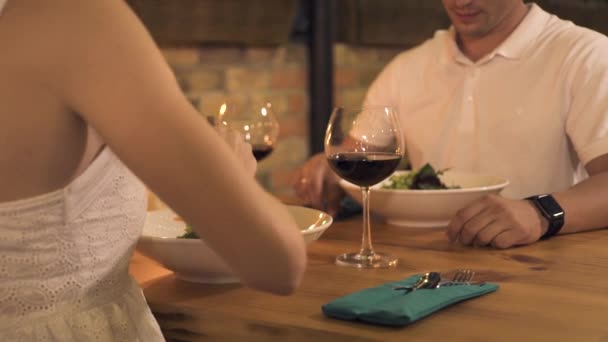 Pareja romántica cenando en un elegante restaurante. Mujer joven alimentando novio en la cena romántica en el restaurante de la noche. Hombre y mujer comiendo en la cafetería. Prueba mi concepto de comida . — Vídeos de Stock