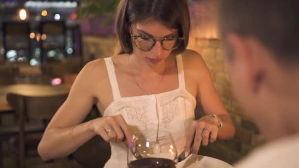 Mujer joven cenando en el restaurante nocturno. Hermosa mujer comiendo ensalada en una cena romántica en un restaurante elegante. Pareja joven cenando en la cafetería . — Vídeos de Stock