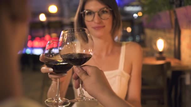 Jovem mulher clinking copo de vinho com o homem no jantar romântico no restaurante. Casal apaixonado beber vinho de vidro em data romântica em restaurante elegante. jantar romântico para dois . — Vídeo de Stock