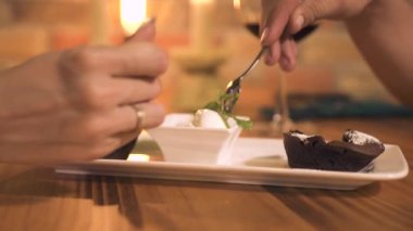 Romantik Çift akşam restoranda kaşık dondurma tatlı ile yeme. Rahat kafede romantik bir akşam yemeğinde dondurma ve çikolatalı kek ile tatlı yeme erkek ve kadın.