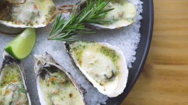 İstiridye peynir, kireç ve plaka üzerinde otlar pişmiş. Sunu menüsü deniz ürünleri Restoran. Akdeniz mutfağı. Deniz ürünleri kompozisyon üstten görünüm hizmet. Sağlıklı beslenme kavramı.