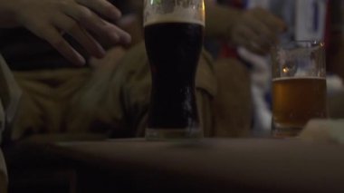 Genç adam pub bar cam koyu bira içme kapatın. Cam spor barında soğuk bir bira içme portre adam.