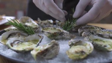 Gıda tasarım tasarım konsepti. Şef pişirmek plaka üzerinde rosemary ile dekorasyon istiridye. Deniz ürünleri Restoran gıda decotation. Lüks Restoran deniz ürünleri yemekleri.