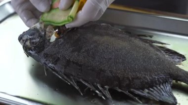 Şef yemek restoran mutfağı sebze garnitür ile dekorasyon ızgara balık. Aşçı taze sebze ile kavrulmuş balık hazırladı. Gıda çizmek bitirmek. Gıda tasarım konsepti.