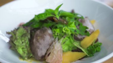 Gıda kompozisyon kapatın. Et ve beyaz tabak soslu sebze salatası. Pişirme gıda kavramı. Füzyon mutfağının Vegetarin salata. Lüks Restoran Menü. Diyet ve beslenme kavramı.