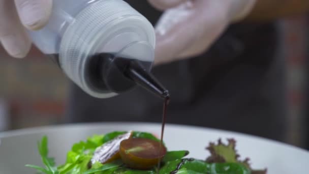Chef kok gieten saus aan plantaardige salade close-up. Koken voorbereiden salade met saus. Proces voorbereiding voedsel. Koken voedsel concept. Gezondheid van voedsel en voeding voeding. — Stockvideo