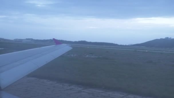 Blick aus dem Flugzeugfenster beim Start auf die Landebahn des Flughafens. Flugzeug bewegt sich auf Landebahn zum Start im Flughafenblick aus dem Fenster. — Stockvideo