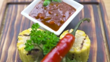 Barbekü eti biftek kompozisyon. Kırmızı acı biber, ot, Mısır ve domates sosu ahşap tahta üzerinde ızgara biftek. Gıda ahşap tahta üzerinde arka plan. Barbekü Restoran menüsünde.