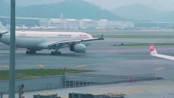 中国香港-2019年3月: 飞机在机场航站楼跑道上起飞。飞机在现代机场降落后在跑道上移动. — 图库视频影像