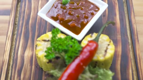 Barbecue vegetabiliska röd peppar, ört, majs och tomat sås sammansättning. Grillad biff kött sammansättning på träskiva. Bakgrunden matkoncept. Menyn i bbq-restaurangen. — Stockvideo