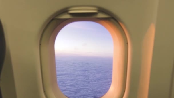 White σύννεφο στον ουρανό θέα από το παράθυρο του αεροπλάνου ενώ golden sunrise. Θέα από το παράθυρο πετώντας αεροσκαφών ηλιοβασίλεμα στο συννεφιασμένο ουρανό. — Αρχείο Βίντεο