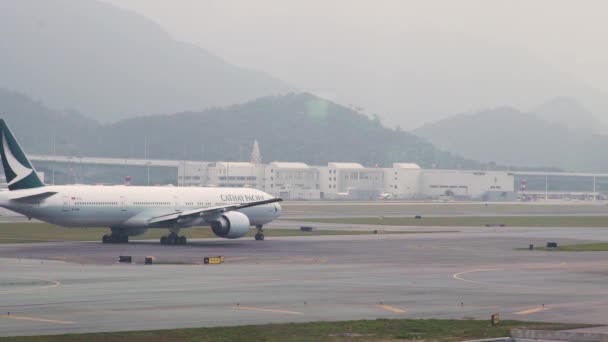 在香港机场航站楼起飞的客机在跑道上行驶, 中国。飞机在国际机场降落后在跑道上移动。空运概念. — 图库视频影像