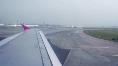 Uçak pist airport penceresinden gökyüzü görünümünde kalkış için hareket. Uçak kanadı penceresinden kalkış Havaalanı Terminal pistte sürüş sırasında.