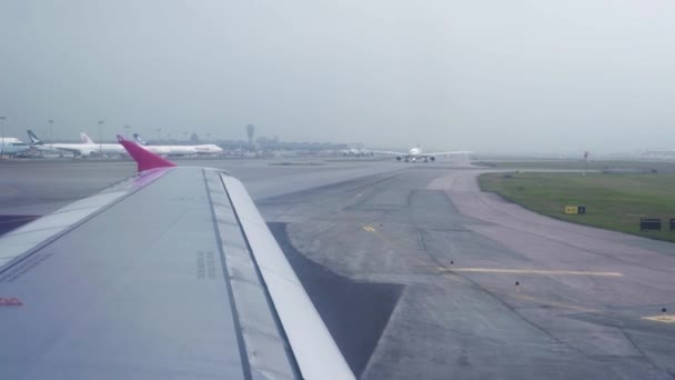 Vliegtuig verplaatsen op de start-en landingsbaan luchthaven voor het opstijgen in lucht uitzicht vanuit venster. Vliegtuig vleugel uit venster terwijl het drijven op de startbaan in vertrek luchthaven terminal. — Stockvideo