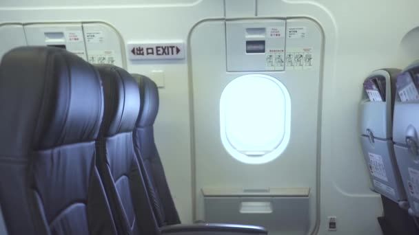 Passenger seats and emergency exit door inside commercial airplane. Interior modern passenger aircraft, passengers chairs and emergency door exit. Economy class cabin airplane. — Stock Video