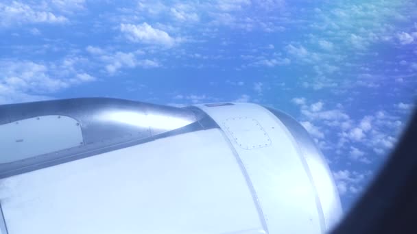 Motor letadla letícího v modré obloze mezi nadýchanými mraky. Pohled z letět letadlem do turbíny na modrou oblohu a bílé mraky na šířku. — Stock video