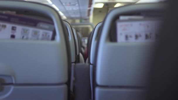 Los pasajeros sillas dentro de cabina avión moderno mientras vuela en el cielo. Los pasajeros se sientan en avión comercial de clase económica durante el vuelo. Personas que viajan en avión comercial . — Vídeo de stock