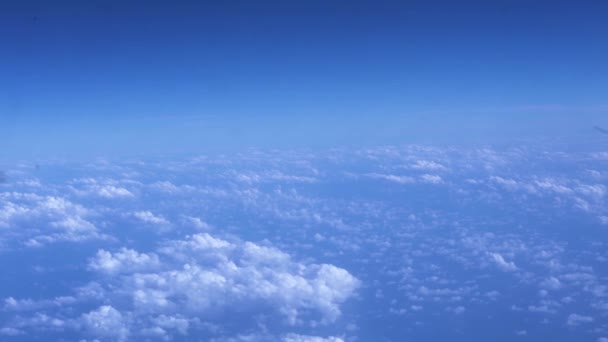 Zonnige hemel en pluizige wolken bekijken vanuit venster vliegtuig. Uitzicht vanaf vliegen vliegtuigen duidelijke blauwe hemel en witte wolken. Bewolkte hemel kopie ruimte landschap. — Stockvideo