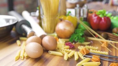 Spagetti ve makarna makarna ahşap masa üzerine yemek pişirmek için malzemelerle. Taze sebze ve İtalyan makarna ve ahşap masa sosu yemek pişirmek için yumurta. İtalyan Gıda kompozisyonu.