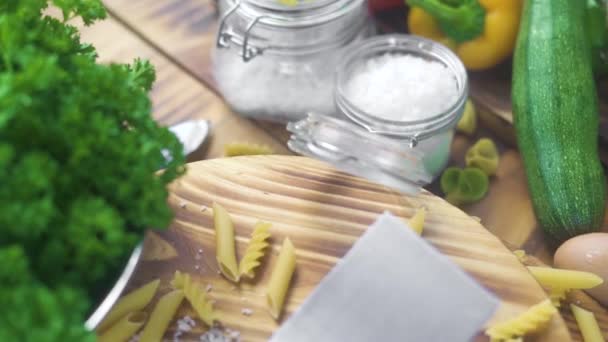 Friss zöldség, a spagetti és a makaróni olasz konyha. Olasz konyha alapanyag. Zöldségek és tészta gyűjtemény fa háttér. Egészséges táplálkozás és a diéta táplálkozás. Követés lövés. — Stock videók