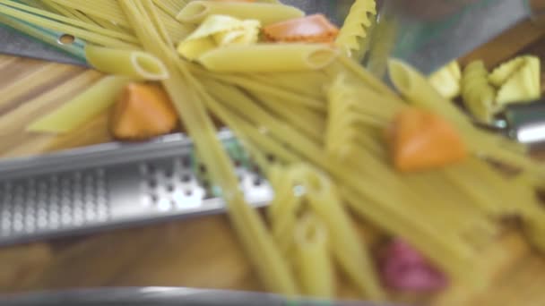 Italiaanse spaghetti en macaroni met verse eieren en rauwkost op houten tafel. Italiaanse voedselingrediënt voor het koken van pasta's en vegetarische salade. De samenstelling van de levensmiddelen op houten achtergrond. Gezonde voeding. — Stockvideo