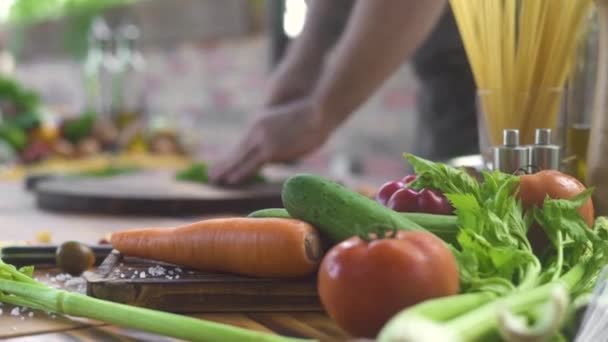 Świeże warzywa na stole w kuchni. Kucharz-cięcie zieleni na tle żywności. Świeży składnik dla Wegetariańska Sałatka na stole w kuchni. Zdrowe odżywianie i odchudzanie. — Wideo stockowe