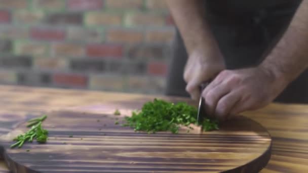 Cuoco cuoco taglio prezzemolo verde su tavola di legno. Cuoco cuoco tritare prezzemolo fresco sul tagliere. Ingrediente per insalata di verdure. Dieta vegetariana. Concetto di cucina alimentare . — Video Stock