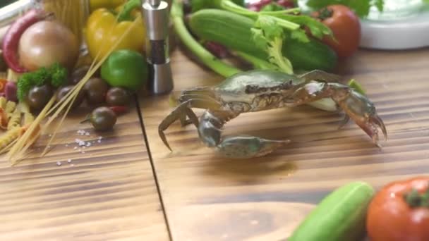 Crabe vivant rampant sur une table en bois sur fond d'ingrédient alimentaire. Crabe sur la table pour cuisiner des pâtes de fruits de mer dans un restaurant italien. Fruits de mer frais au restaurant cuisine méditerranéenne . — Video