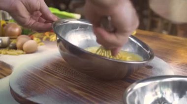 El Şef makarna hamur için yoğurma önce kase mutfak fırçalamak ile yumurta dayak. İtalyan restoranda pizza için hamur pişirmek için yumurta fırçalama pişirin. Aşçı yemek.
