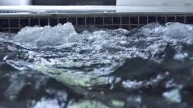 Spa merkezinde jakuzi havuzunda su sıçraması. Lüks spa resort otelde jakuzi küvette kaynar su. Hidroterapi ve hidromasaj konsepti.