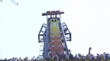 Lunaparkta aşırı cazibeye binen insanlar. Mutlu arkadaşlar eğlence parkı heyecan verici roller coaster binmek eğlenmek.