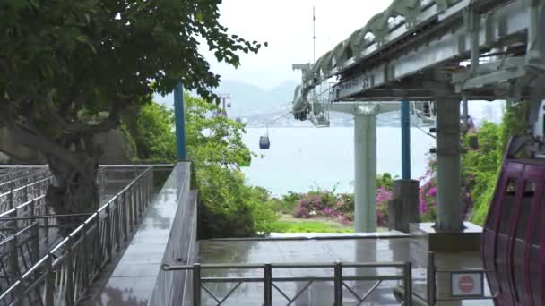 Seilbahnkabinen, die sich auf einer Seilbahn für den Personentransport über das Meer in der modernen Stadt bewegen. Seilbahn mit Kabinen zwischen Insel im Meer. — Stockvideo