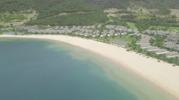 Luxusvillen und Villen mit Swimmingpools am Ufer des blauen Meeres auf grünen Bergen und Hügeln Landschaft. Resort-Hotels am Meer Strand und grünen Hochland Hintergrund. Luftbild. — Stockvideo