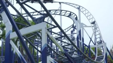 Eğlence parkında heyecan verici roller coaster binmek neşeli insanlar. Eğlence parkında eğlenen ve geri dönüşe binen mutlu insanlar.