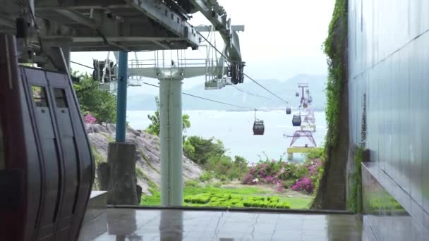 Cabine della funivia che si muovono sulla via di corda per il trasporto di passeggeri attraverso il mare nella città moderna. Cabinovia con cabine auto tra l'isola in mare . — Video Stock