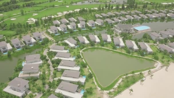 Modern Stugby med lyxig herrgård på sjöstranden, grön gräsmatta bakgrund. Luftutsikt arkitektur lyxby med hus, pool och golfbana. — Stockvideo