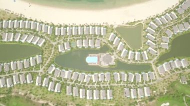 Turistik tatil villa ve oteller deniz kıyısında drone görünümü. Mavi deniz kıyısında konak ve yüzme havuzu ile lüks yazlık köy. Okyanus kıyısında hava peyzaj mimarisi turistik otel.