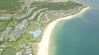 Tropikal ada ve uçan drone mavi deniz manzara görünümü lüks tatil otelleri ve villalar. Yüzme havuzu ve mavi deniz kıyısında hava peyzaj turist otel.